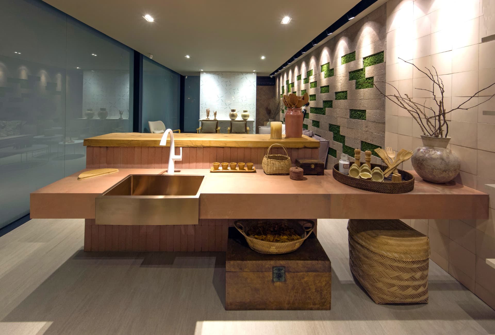 Showroom Casa Rara: ilha de cozinha com cuba em cobre, bancada em madeira e painel de musgo