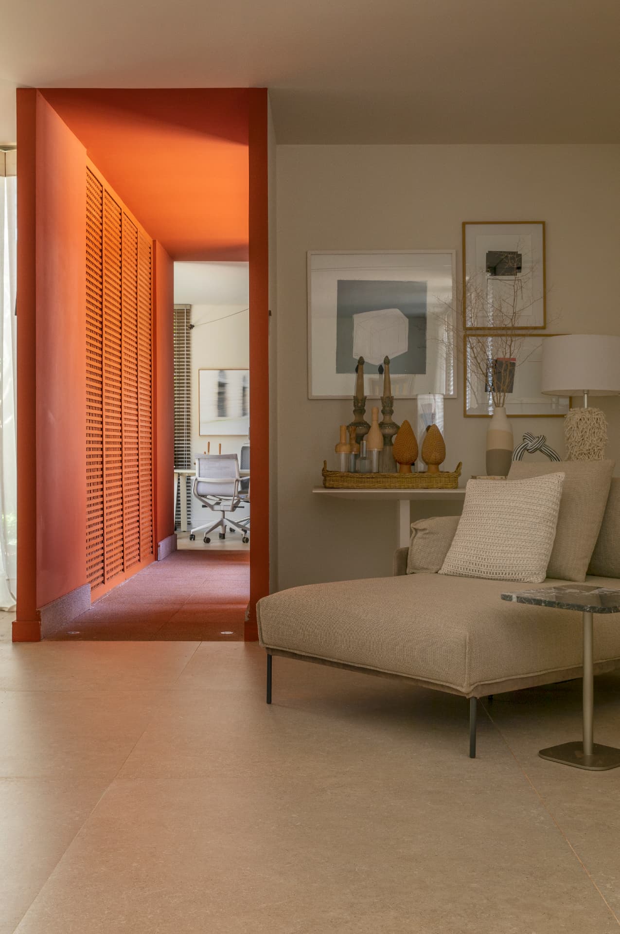Estar com chaise clara e passagem em terracota para o home office