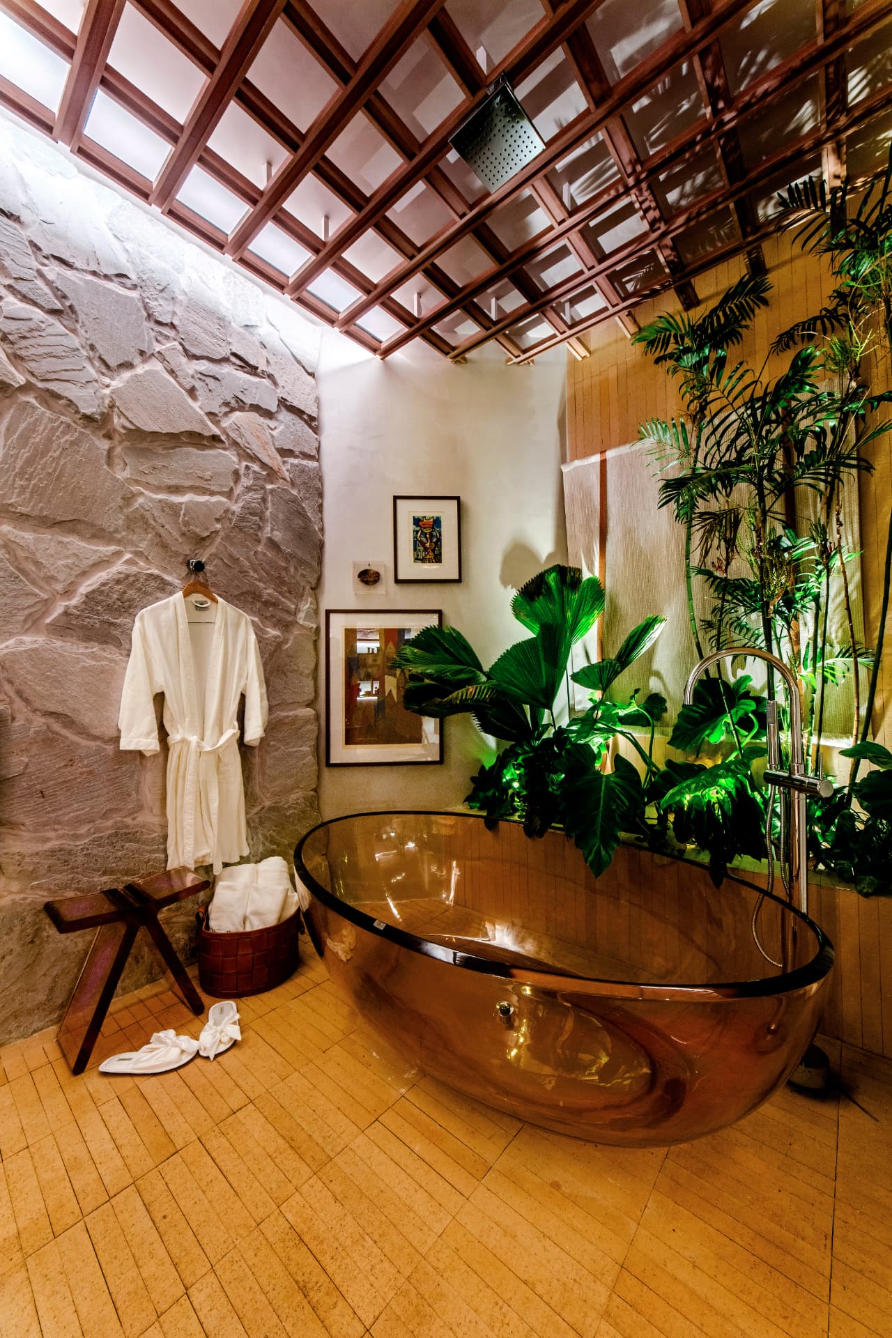 Área de banho estilo spa com banheira escultural e vegetação