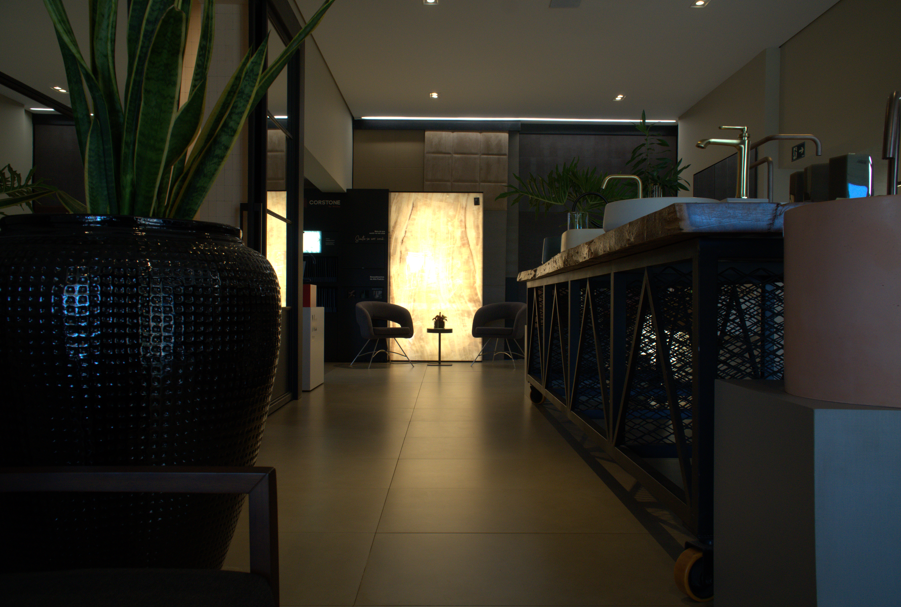 Corredor do showroom com bancada de pia e iluminação cenográfica