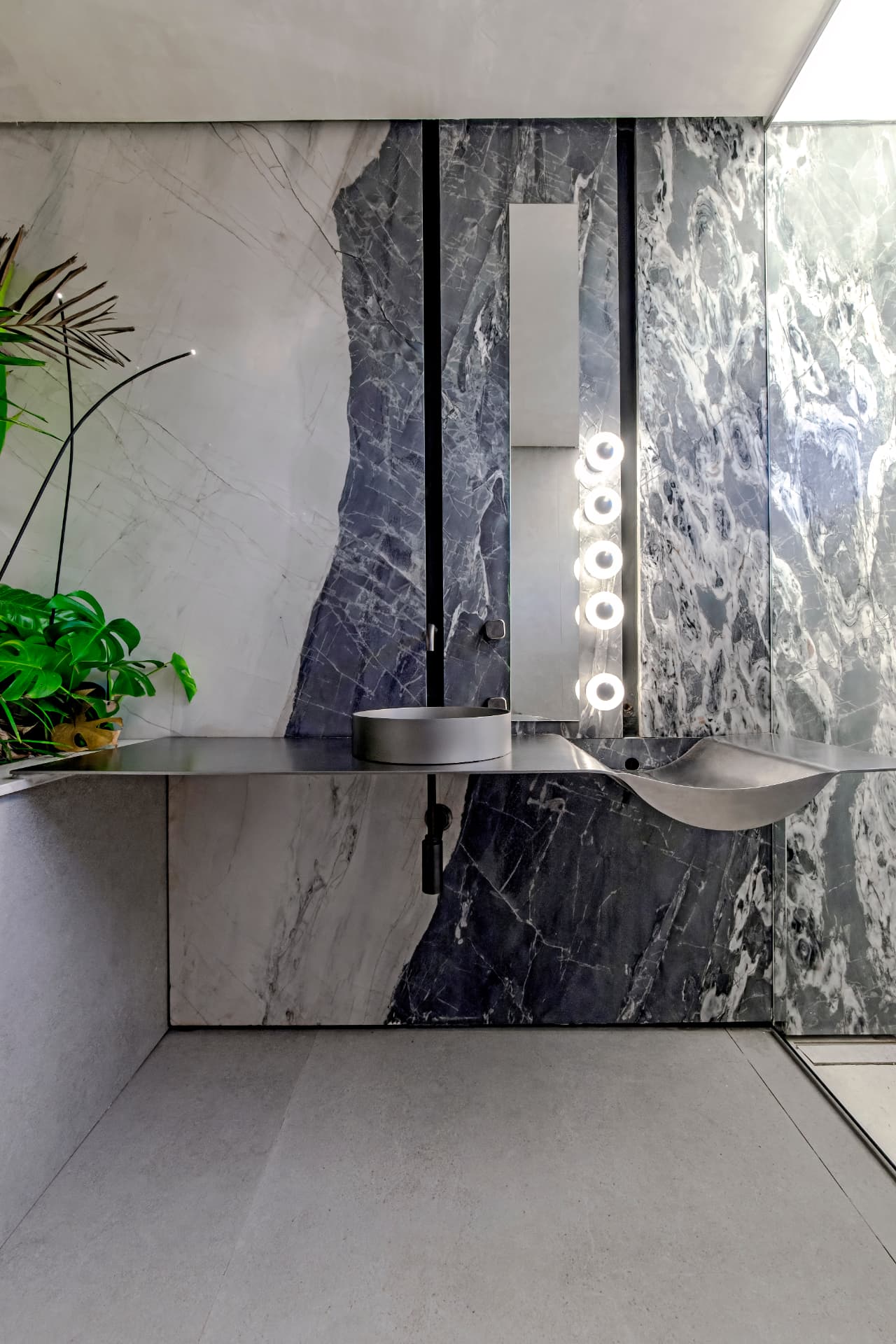 Lavabo com mármores de veios marcantes e metais minimalistas